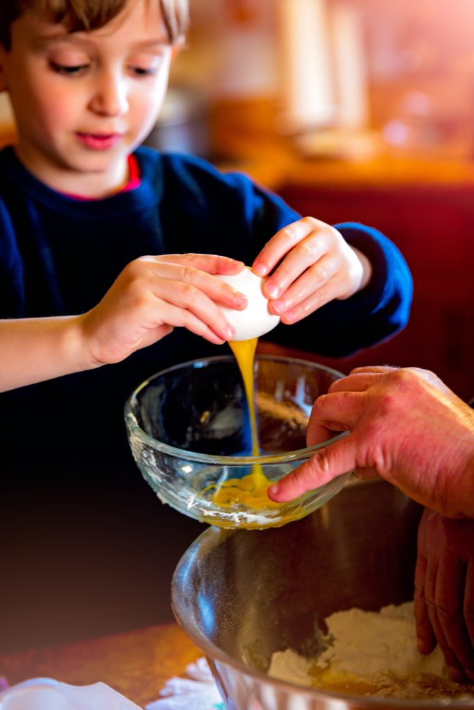 Boy cracking egg into bowl