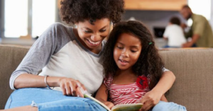 mother and child reading together on a sofa.