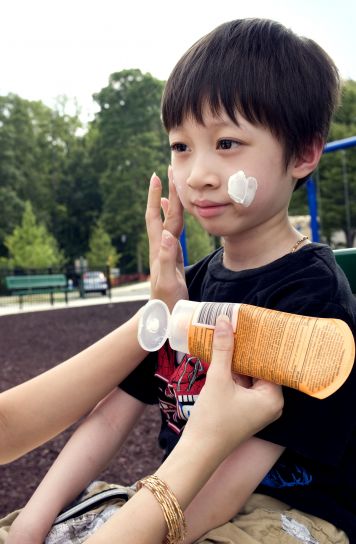young-boy-was-receiving-a-reapplication-of-a-coating-of-protective-sunscreen-by-his-mother