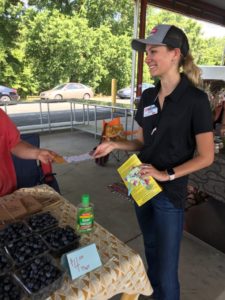 Woman smiling at Farmers Market stand