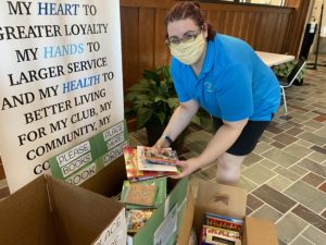 4H Program Assistant looking at book drive donations