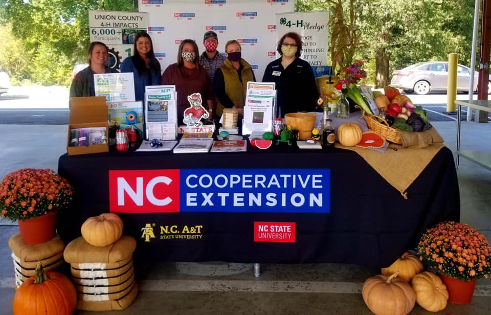 6 people standing behind a table that says N.C. Cooperative Extension