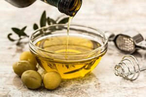 Yellow Olive Oil Being Poured into a Small Glass Bowl