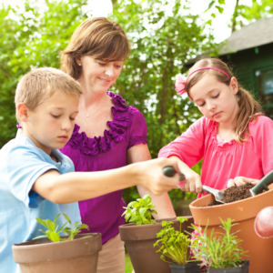 Mother helping her children plant container gardens