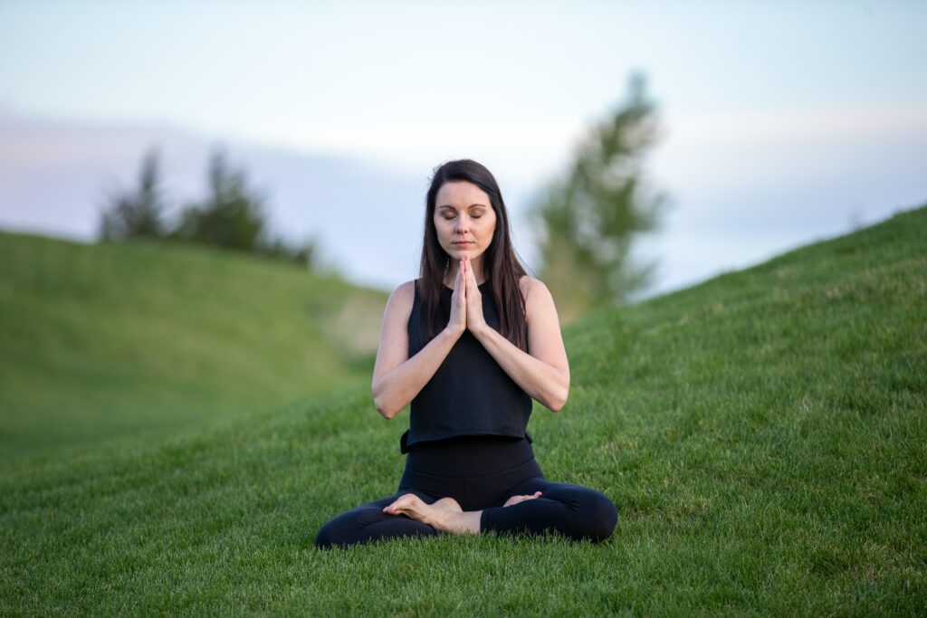 Woman Doing Yoga on Green Grass