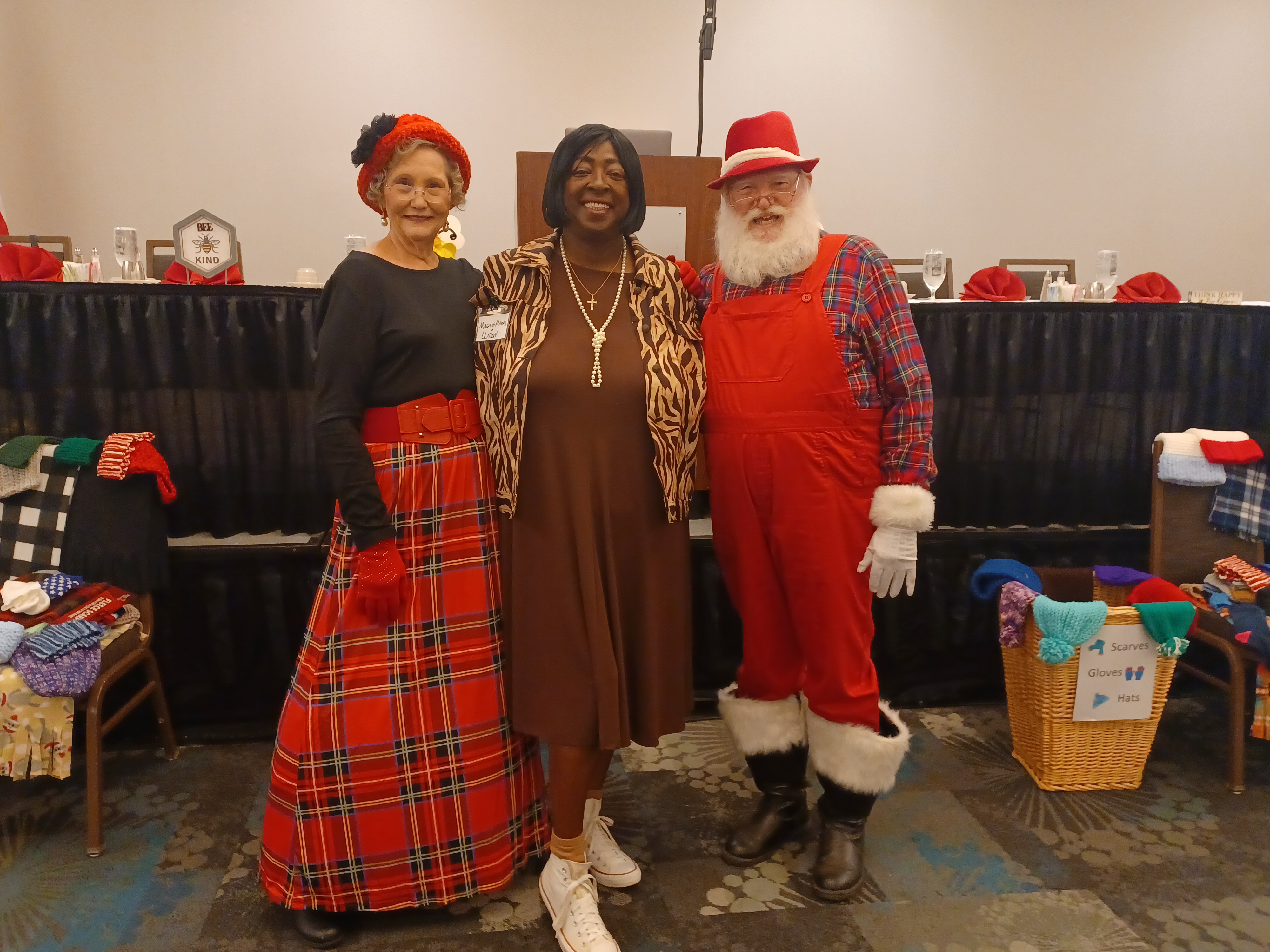 Volunteer takes picture with Santa and Mrs. Claus