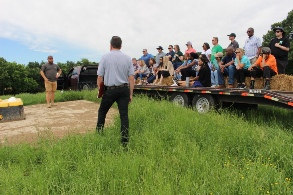 Farmer Josh Eudy and Soil and Water Conservationist Andy Cranfill address attendants around water unit where his cows get water while out in the pasture.