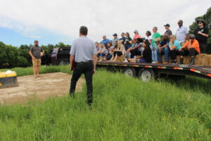 Farmer Josh Eudy and Soil and Water Conservationist Andy Cranfill address attendants around water unit where his cows get water while out in the pasture.